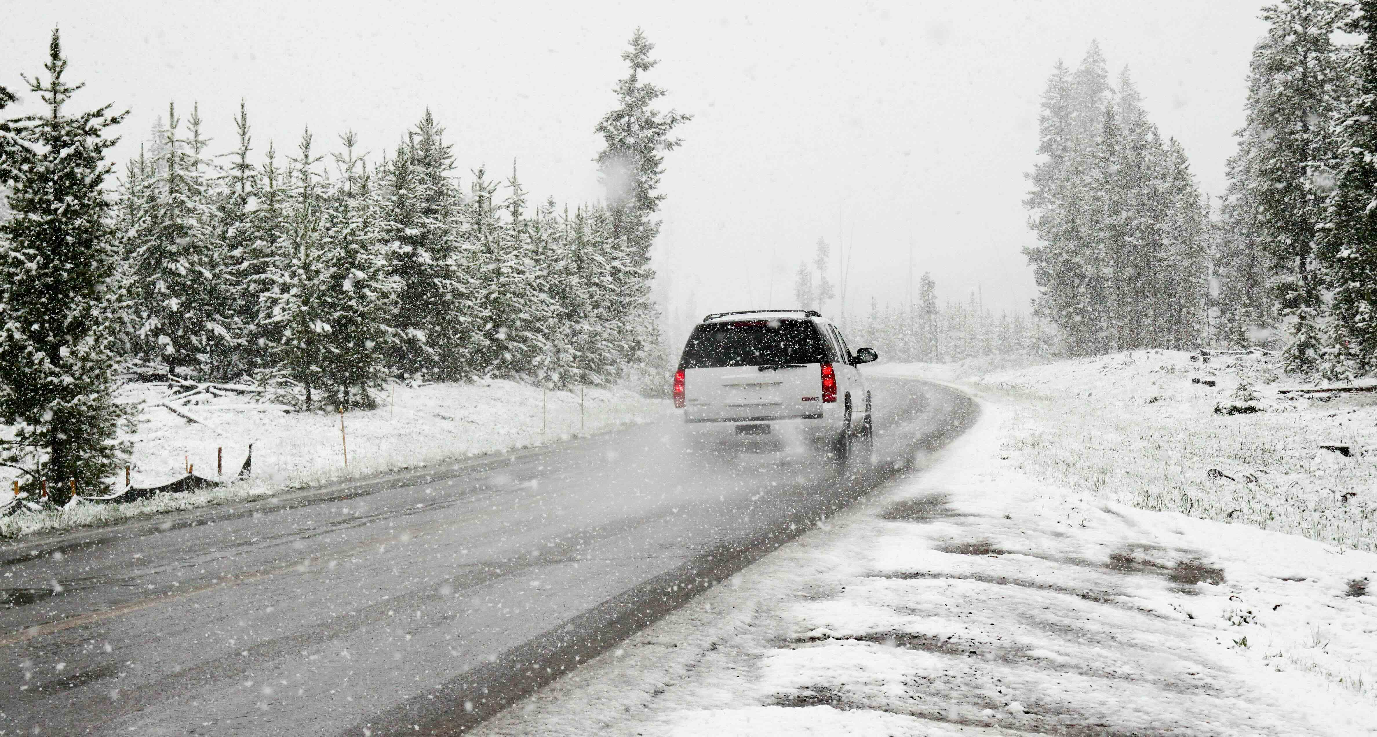 A car drives through a snowy Ontario road in winter.