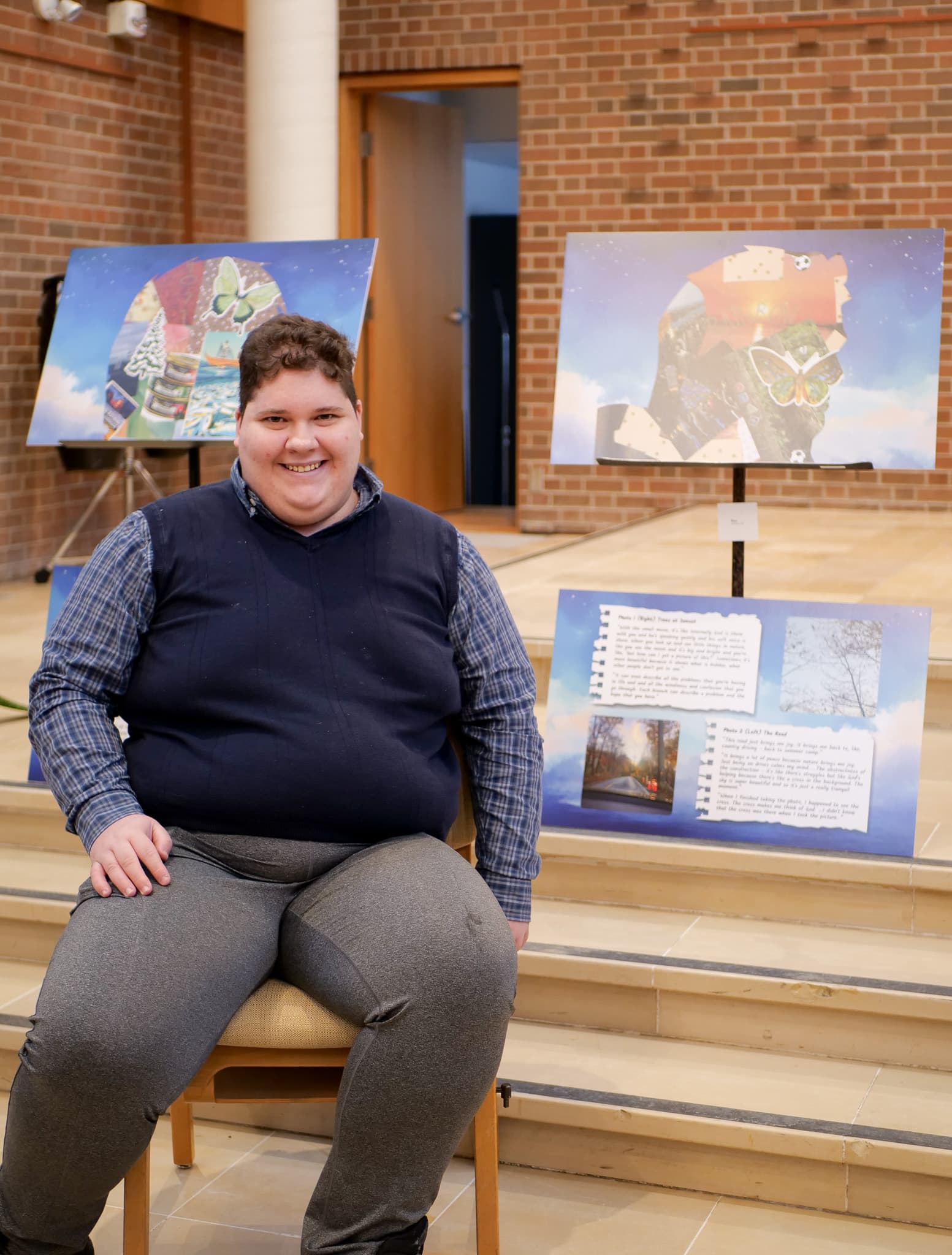 Raee sits proudly by his collage and photovoice project.